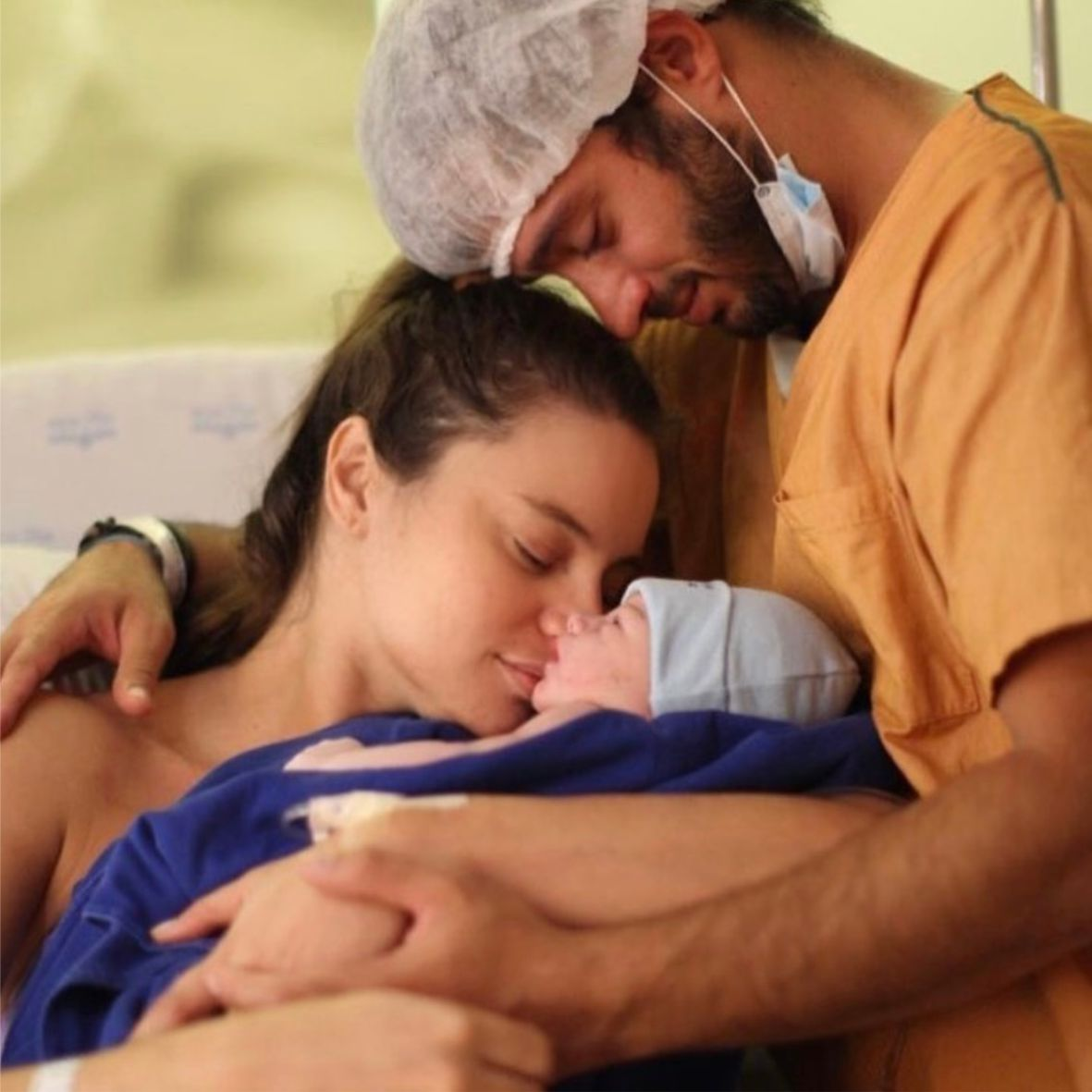 Mãe e pai acolhendo o bebê recém-nascido logo após o parto